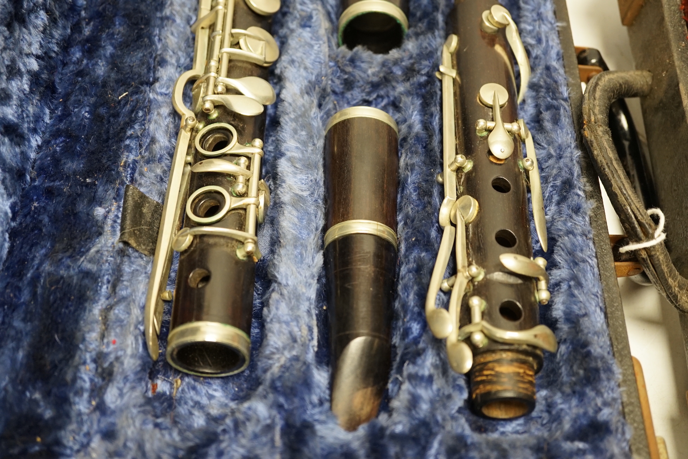 Two cased unmarked clarinets with early key systems, one mid 19th century in rosewood, one with light brown Bakelite body